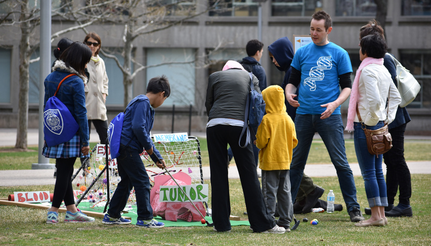 a group of young people putt through a cancer themed minigolf course