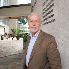 Phil Sharp standing next to the MIT Biology building