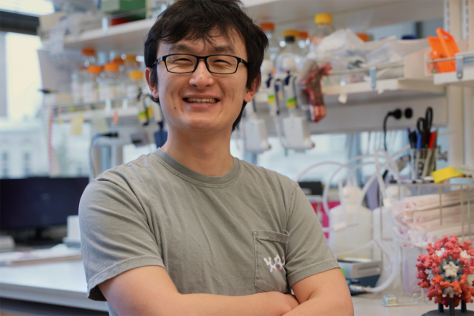 Bingxu Li, smiling and arms crossed, standing in a lab