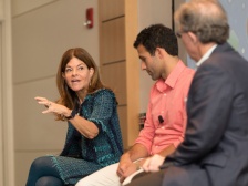 three people in discussion on a panel