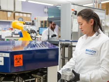 Two researchers working near a robotic arm